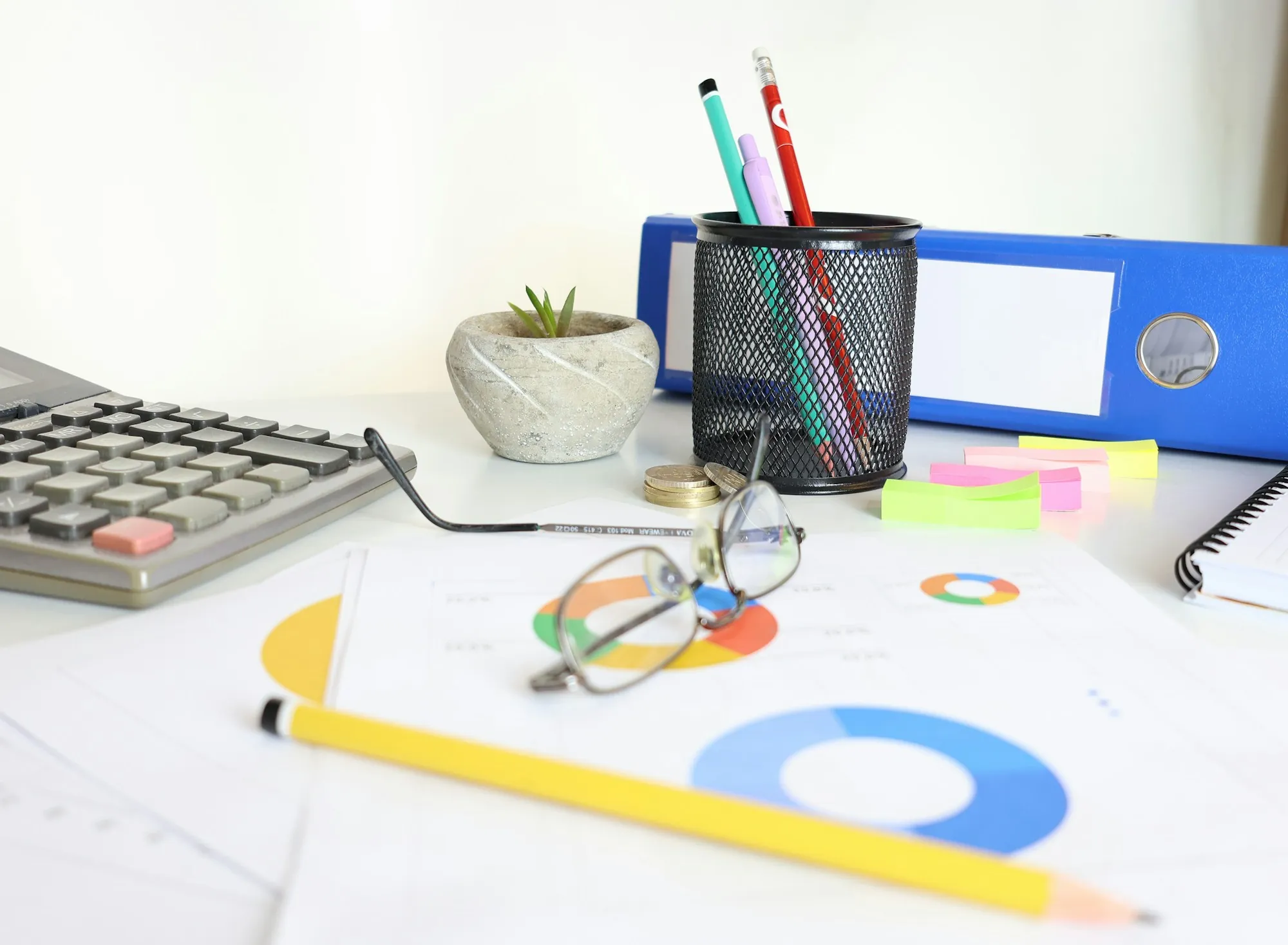 Office desk with a calculator, charts and pencils