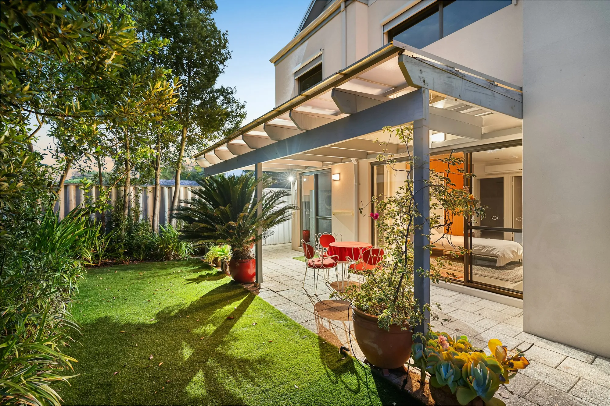 Covered patio beside a lawn and potted plants at a modern home, illustrating pricing a home with comparable sales in McFarland